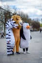 Animators in the costume of a lion, a penguin and a zebra from the cartoon Madagascar in the city.