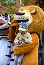 A man in a lion costume on a city street embraces and takes photos with passers-by. Advertising on the street. Work in advertisin