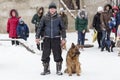 the man walks with a German shepherd in the winter