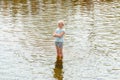 Russia Karelia Kondopoga - July 08-2014: a girl stands in a fountain in a puddle of water and soaked serious