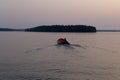 Russia, Karelia. White nights. Lake Muezero. Man on an inflatable boat floating on the lake