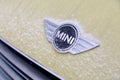 Russia Kemerovo 2019-01-07 Close view of Mini Cooper car logo badge on yellow Mini Cooper car covered snow Royalty Free Stock Photo