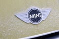 Russia Kemerovo 2019-01-07 Close view of Mini Cooper car logo badge on yellow Mini Cooper car covered snow Royalty Free Stock Photo