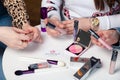 Russia Kemerovo 2019-04-15 Closeup collection testers of professional cosmetic in make-up artist hands. Make up brush, lip gloss