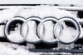 Russia Kemerovo 2018-12-23 closeup metal emblem brand icon Audi A6 with four rings, covered with fluffy snow. Concept German