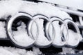 Russia Kemerovo 2018-12-23 closeup metal emblem brand icon Audi A6 with four rings, covered with fluffy snow. Concept German