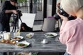 Russia Kemerovo 2019-03-10 girl photographer taking pictures on professional camera Canon 5D Mark IV and various dishes, salads on