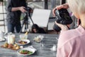 Russia Kemerovo 2019-03-10 girl photographer taking pictures on professional camera Canon 5D Mark IV and various dishes, salads on