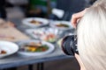 Russia Kemerovo 2019-03-10 girl photographer taking pictures on professional camera Canon 5D Mark IV and various dishes, salads on