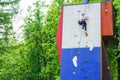 Russia Kemerovo 1.06.2020 Little girl climbing on artificial boulders wall
