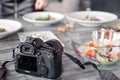 Russia Kemerovo 2019-03-10 professional camera Canon 5D Mark IV and many different dishes, fish, salads on table in restaurant. Royalty Free Stock Photo