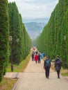 Russia, Kislovodsk 02.11.2021. Holidaymakers stroll along the alley with tall thujas planted along the surrounded hills