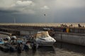 In the summer, yachts stood at the pier at sea, and people were resting on the coast