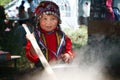 Russia, Magnitogorsk, - June, 16, 2011. A little girl in traditional folk costume prepares a pilaf during Sabantuy - the folk