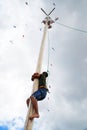 Russia, Magnitogorsk, - June, 15, 2019. A man climbs onto a tall wooden pole for a gift during Sabantuy - the national holiday of