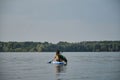 Russia, Moscow - August 2022. Stand up paddle dog. Young woman paddles in lake sitting on inflatable SUP board with Australian Royalty Free Stock Photo