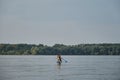 Russia, Moscow - August 2022. Stand up paddle dog. Young woman paddles in lake sitting on inflatable SUP board with Australian Royalty Free Stock Photo