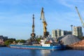 Russia, Moscow August 2018: Unloading of the barge with crushed stone port cranes