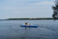 Russia, Moscow - August 2022. Young woman with Australian Shepherd life jacket sits on inflatable SUP board in lake. Elderly Royalty Free Stock Photo