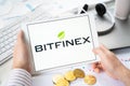 Russia Moscow 05.05.2021.Businessman holding tablet with logo of cryptocurrency stock exchange Bitfinex.Buy,sell,change crypto