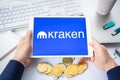 Russia Moscow 05.05.2021.Businessman holding tablet with logo of cryptocurrency stock exchange Kraken. Buy,sell,change crypto