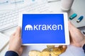 Russia Moscow 05.05.2021.Businessman holding tablet with logo of cryptocurrency stock exchange Kraken. Buy,sell,change crypto