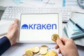Russia Moscow 05.05.2021.Businessman holding tablet with logo of cryptocurrency stock exchange Kraken. Buy,sell,change crypto