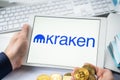 Russia Moscow 05.05.2021.Businessman holding tablet with logo of cryptocurrency stock exchange Kraken. Buy,sell,change crypto