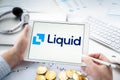 Russia Moscow 06.05.2021.Businessman with tablet.Logo of cryptocurrency stock exchange Liquid.Trading blockchain platform to buy,