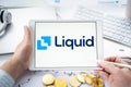 Russia Moscow 06.05.2021.Businessman with tablet.Logo of cryptocurrency stock exchange Liquid.Trading blockchain platform to buy,