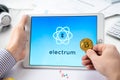 Russia Moscow 06.05.2021 Businessman, tablet. Logo of software cryptocurrency wallet,gateway Electrum. Blockchain application to Royalty Free Stock Photo