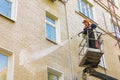 22.05.2019 Russia, Moscow. The employee of municipal services washes a facade of the multi-storey building by means of the high-