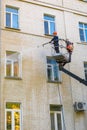 22.05.2019 Russia, Moscow. The employee of municipal services washes a facade of the multi-storey building by means of the high-