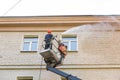 22.05.2019 Russia, Moscow. The employee of municipal services washes a facade of the multi-storey building by means of the high-