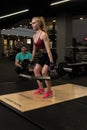 RUSSIA, MOSCOW - FEB 11, 2022: Instructor and client girl deadlift blonde trap bar personal teach, for instructions