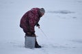 winter fishing on the lake. Winter fishing on the pond. A man with a fishing rod on frozen lake.