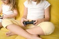 Russia,Moscow-03.18.20.Girls play video games, hold in hands joysticks from game console.Sitting at home in quarantine from