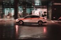 City street scene with white taxi vehicle in motion. Fast moving taxi car on Moscow winter streets at night Royalty Free Stock Photo