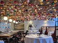 Modern white interior with bright details and New Year decorations on the ceiling in a BURO TSUM restaurant, Moscow.