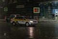 Motion city street scene with yellow taxi vehicle. Fast moving yandex taxi car on Moscow wet winter streets. Blured auto motion at