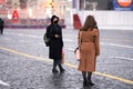 Russia, Moscow, January 25, 2021: two girls in medical masks, one of whom is dressed in a Gothic style, walk through Red Square. S