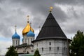 Russia, Moscow, July 2018 - Novospassky Monastery. Fortress wall with tower and domes of the temple against the dark cloudy sky Royalty Free Stock Photo