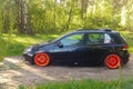 Russia, Moscow - June 01, 2019: Black Volkswagen Golf Mk6 tuned with ragtop and orange wheels. Stance tuning on air suspension in Royalty Free Stock Photo