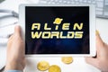 Russia Moscow 05.05.2021. Man holding tablet with logo of gaming platform Alien Worlds. Crypto coins,tokens mining online game.