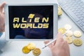 Russia Moscow 05.05.2021. Man holding tablet with logo of gaming platform Alien Worlds. Crypto coins,tokens mining online game.