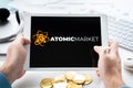 Russia Moscow 05.05.2021.Man holding tablet with logo of NFT marketplace Atomic market. Non fungible tokens for cryptocurrency WAX