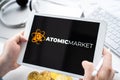 Russia Moscow 05.05.2021.Man holding tablet with logo of NFT marketplace Atomic market. Non fungible tokens for cryptocurrency WAX Royalty Free Stock Photo