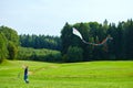 Russia, Moscow, 02.06.2019, man launches a kite in a huge green field, next to a dense forest Royalty Free Stock Photo