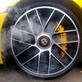 Russia, Moscow - May 04, 2019: Yellow Porsche 911 Turbo S light alloy wheels with carbon ceramic brakes and smoke from it. Close