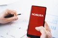 Russia Moscow 29.03.2021 Mobile phone with logo of Nomura Holdings broker.Investment finance company,hedge fund.Margin call,